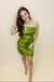 Woman wearing a green sequin dress against a plain background
