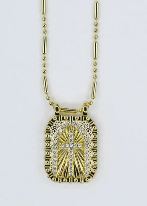 Gold necklace with a cross pendant on a white background